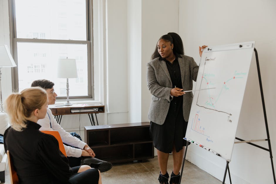A professional woman leads a presentation in an office conference room, fostering workplace diversity.